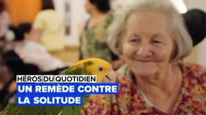 Une vieille dame souriant à un oiseau